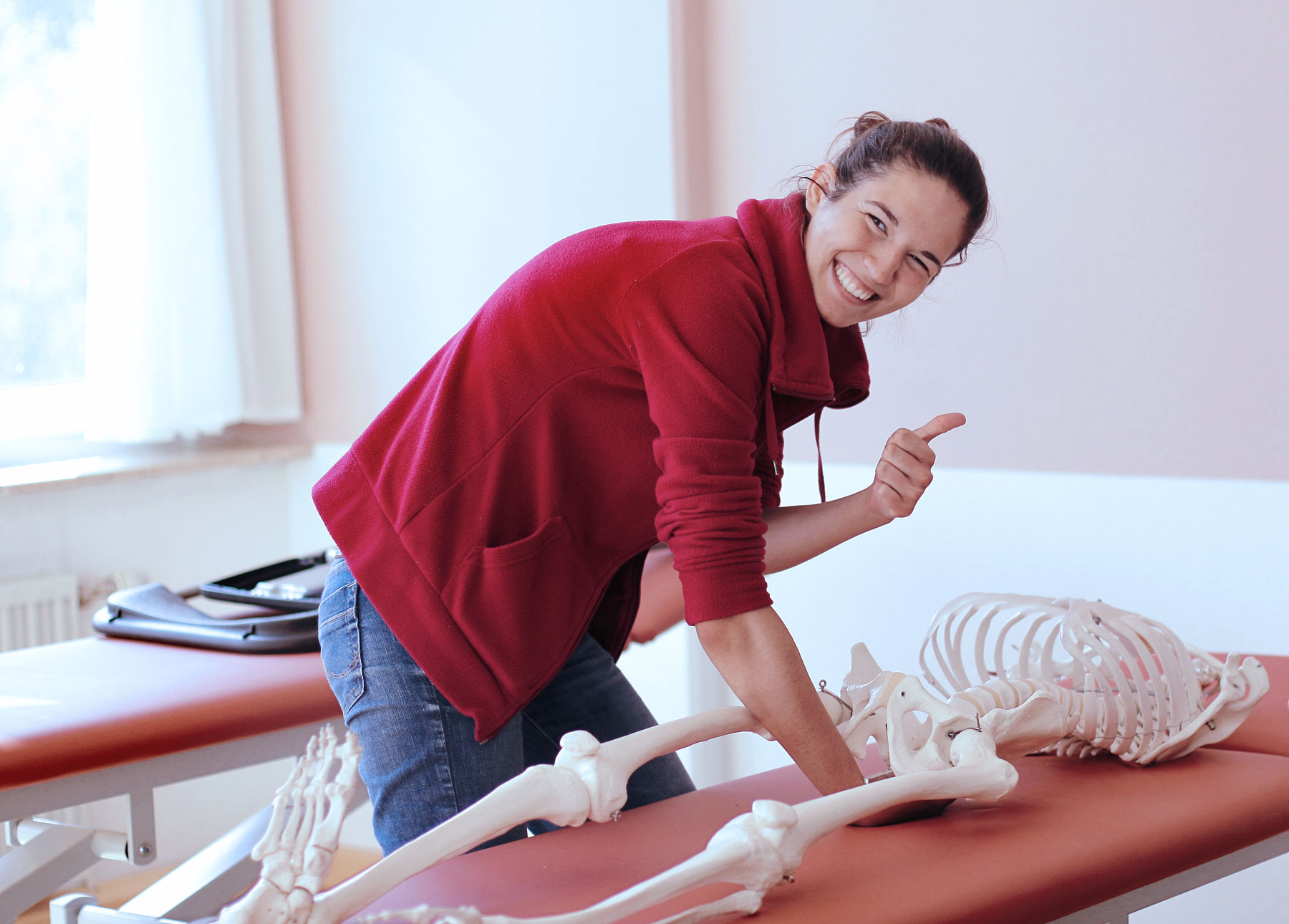 Eine lächelnde Frau übt an einem anatomischen Modell am College Sutherland.